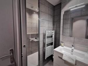 y baño con lavabo y espejo. en Hotel Le Pont Neuf, en Saint-Affrique