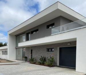 een modern huis met een garage bij A Casa da Corsica in Pêro Moniz