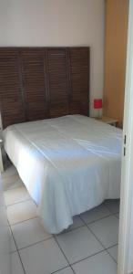 a bedroom with a white bed with a wooden headboard at hippocampe f2 in Fréjus +8 photos