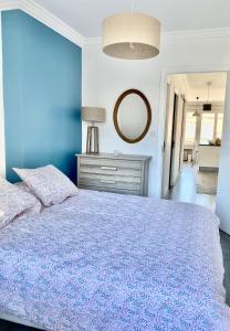 Dormitorio azul con cama y espejo en Coeur d'Annecy, Idéalement situé en Annecy