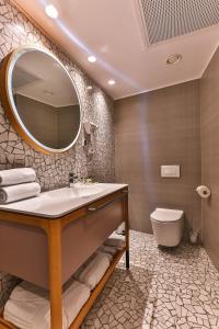 bagno con lavandino, specchio e servizi igienici di Carine Hotel Centar a Podgorica Altre 37 foto