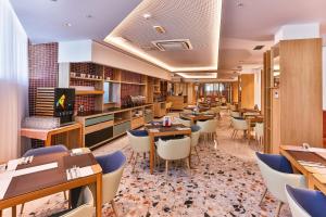 un ristorante con tavoli e sedie in una stanza di Carine Hotel Centar a Podgorica