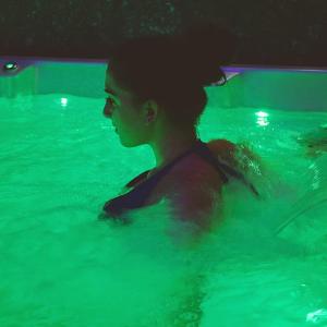 une jeune fille nage dans une piscine dans l'établissement J13 Appartamento con SPA Privata, à Pavia