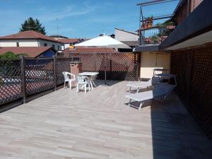 un patio con tavoli, sedie e ombrellone di J13 Appartamento con SPA Privata a Pavia