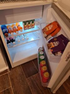 einen offenen Kühlschrank mit Getränken und Speisen darin in der Unterkunft La Boutique Aparts Temporarios Corrientes Pleno centro in Corrientes