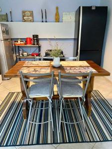 a wooden table with two chairs and a kitchen at Sunny Garden in Plataria