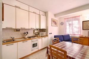 cocina con armarios blancos, mesa, mesa y sillas en Maremonti en Casarza Ligure