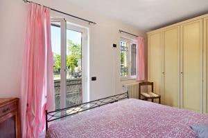 1 dormitorio con 1 cama y una ventana con cortinas rosas en Maremonti en Casarza Ligure