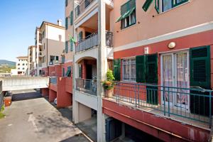a building with green shutters and balconies on a street at Maremonti in Casarza Ligure