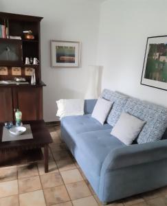 niebieską kanapę w salonie ze stołem w obiekcie Ferienwohnung Bibert w mieście Michelstadt