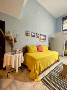 a bedroom with a yellow bed and a table at Sunny Garden in Plataria