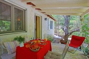 a red table and chairs on a patio at Kitrini Luxury Cottage in Zenempisátika