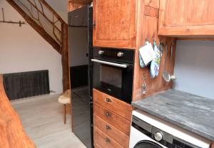 una cocina con nevera negra y una escalera en Tríplex Rústico-Moderno hasta 18 plazas - Pobla de Lillet, en La Pobla de Lillet