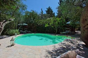 a small swimming pool in a yard with trees at Prasini Luxury Cottage in Oziás