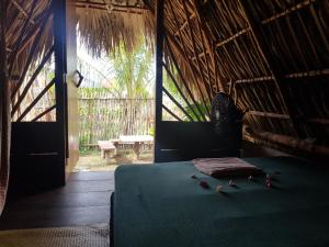 a bedroom with a bed in a straw hut at Calypso cabanas in El Paredón Buena Vista