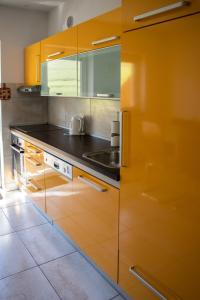 a kitchen with orange cabinets and a sink at Apartma Sonček, on the ski slopes, balcony, private parking in Kranjska Gora