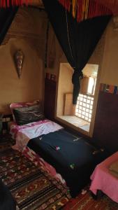 a bedroom with a bed and a window in a room at Kasbah Maktob Tamnougalt in Agdz