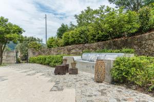 uma parede de pedra com um sofá e duas mesas em Quinta das Pirâmides - Morgada de Romariz em Vila Nova de Famalicão