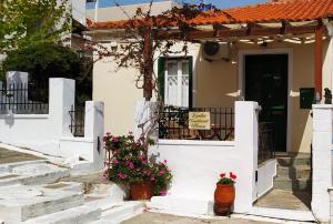 una casa blanca con flores delante en Kontos-Traditional house in Andros beach, en Ándros
