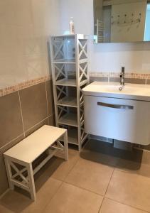La salle de bains est pourvue d'un lavabo, d'un banc et d'un miroir. dans l'établissement La Perle Marine, Luxe et Raffinement, appartement T4 vue mer, à Narbonne