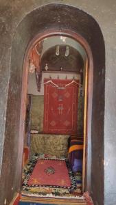 Cette petite chambre est dotée d'une porte rouge et d'un tapis. dans l'établissement Kasbah Maktob Tamnougalt, à Agdz
