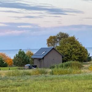 an old barn sitting in a field of grass at Beach House Kaltene in Kaltene