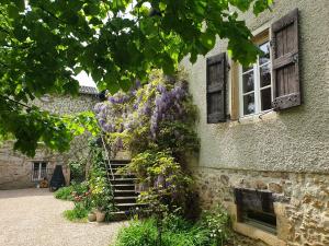 una casa con flores púrpuras creciendo a su lado en VILLA VILLOU, en Romanèche-Thorins