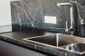 a kitchen sink with a faucet on top of it at Beach House Kaltene in Kaltene +19 photos