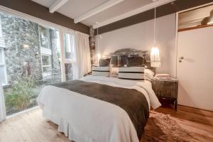 a bedroom with a large bed and a large window at Runa Moraira Apart & Spa in Mar de las Pampas +99 photos