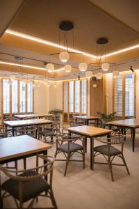 a dining room with tables and chairs and windows at MYR Puerta Serranos in Valencia