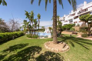 a palm tree in a circle in front of a building at Incredible apartment with sea views and balcony in Mijas