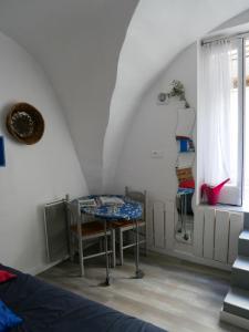 Zimmer mit einem Tisch, einem Bett und einem Fenster in der Unterkunft Le Biou in Cassis