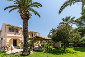 una palmera frente a una casa en Villa Marina Mare en Acharavi