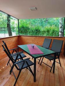 蒂薩菲賴德的住宿－hé,Tisza!，木甲板上的一张桌子和两把椅子