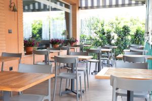 a restaurant with tables and chairs and windows at Hotel Ariston in Imperia