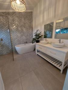 a bathroom with a tub and two sinks and a bath tub at The Lake House in Hluhluwe