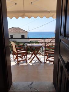 a balcony with a table and chairs and the ocean at Zaga Apartments - Flats in Koroni