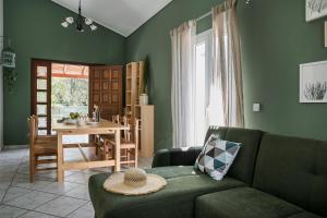 a green living room with a couch and a table at Emily Villas in Sami