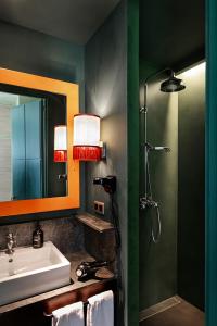 a bathroom with a sink and a shower with a mirror at chic&basic Habana Hoose in Barcelona