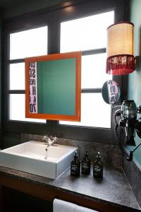 a bathroom sink with a mirror next to a window at chic&basic Habana Hoose in Barcelona