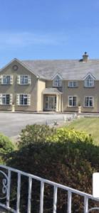 a large house with a fence in front of it at Kielty's of Kerry Bed and Breakfast in Waterville