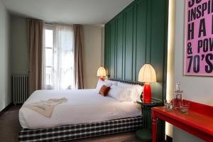 a bedroom with a large bed with a green headboard at chic&basic Habana Hoose in Barcelona