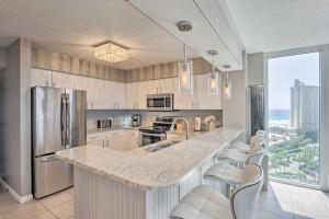 a kitchen with a large counter with chairs in it at The Terrace at Pelican Beach Resort: View + Pool! in Destin