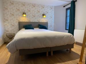 a bedroom with a large bed with blue pillows at Villa Madeleine rénovée plage hyper centre in Trouville-sur-Mer