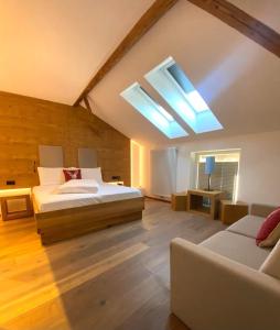 a large bedroom with a bed and a skylight at Gasthof Zum Hirschen Margreid in Magrè allʼ Adige