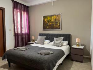 1 dormitorio con 1 cama grande y una pintura en la pared en The Lemon Tree, en Taormina