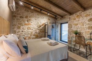 um quarto com uma cama numa parede de pedra em Evangelia Casa, comfy stay, centrally, with views! em Heraclião