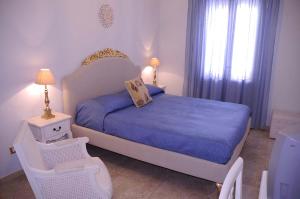 Schlafzimmer mit einem Bett mit blauer Decke in der Unterkunft AFFITTACAMERE A TRE MINUTI IN SPIAGGIA Il Veliero in San Vito lo Capo