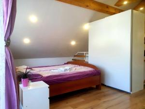 a small bedroom with a bed with purple sheets at Apartma DAVID in Zgornje Gorje