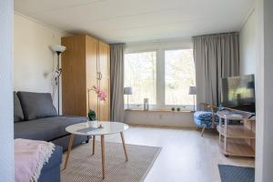 uma sala de estar com um sofá e uma mesa em Lilla Paradiset em Tomelilla